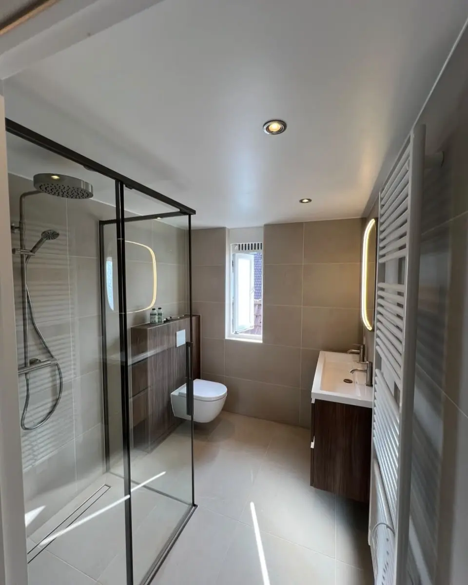 Badkamer en toilet met glazen douchewand, na de renovatie