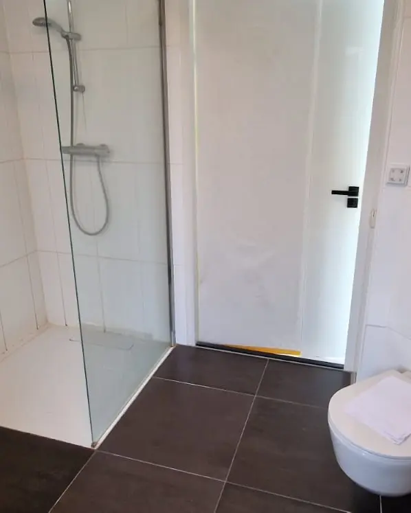 Strakke badkamer in grijs en zwart, voor de renovatie