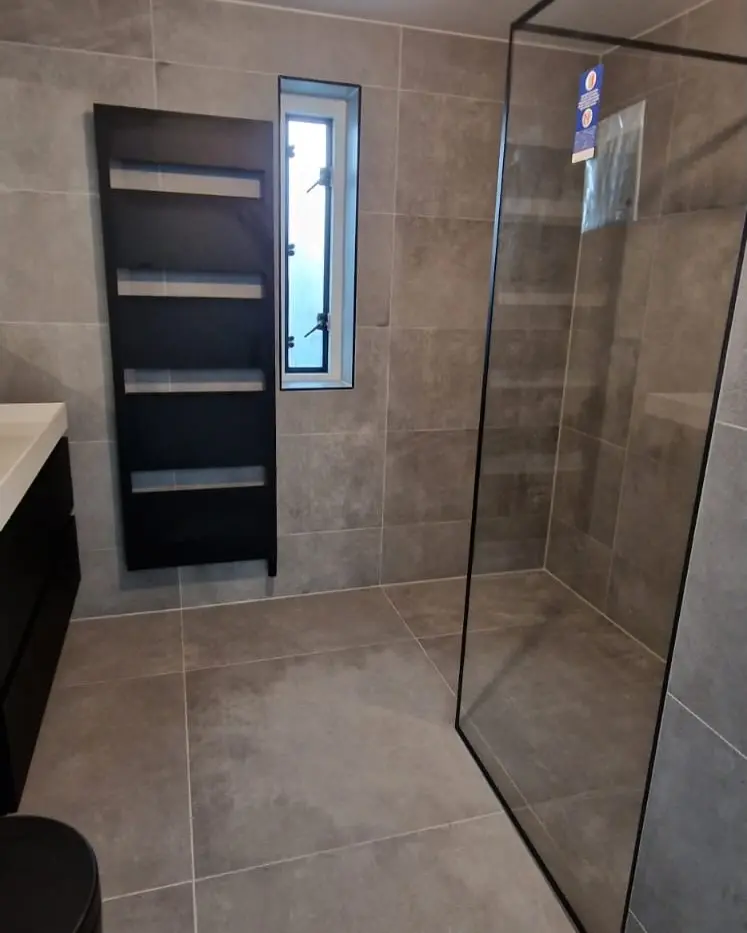 Strakke badkamer in grijs en zwart, na de renovatie