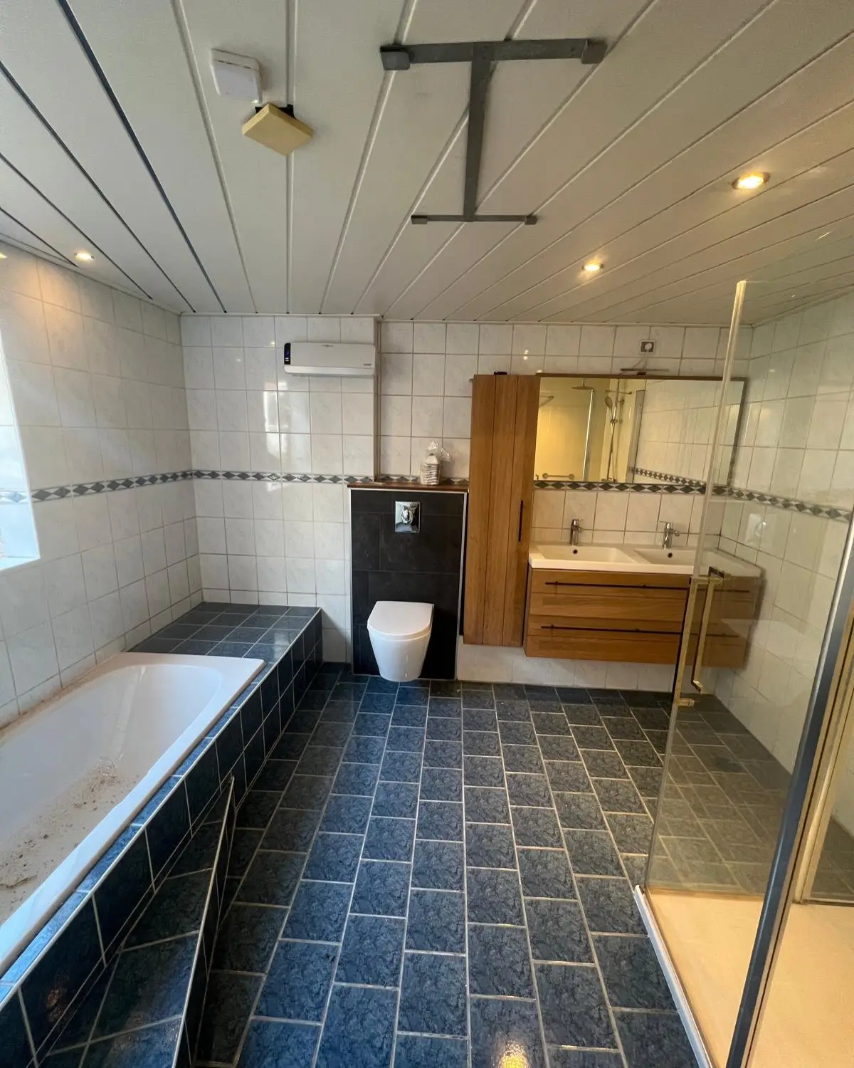 Badkamer met ligbad en inloopdouche, voor de renovatie